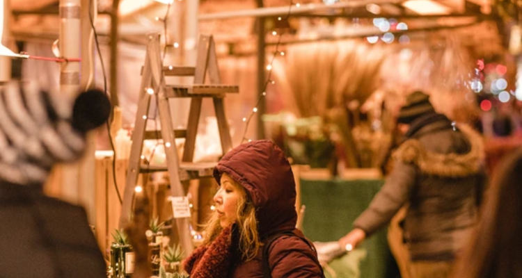 Woman shopping at stalls at York Christmas markets.